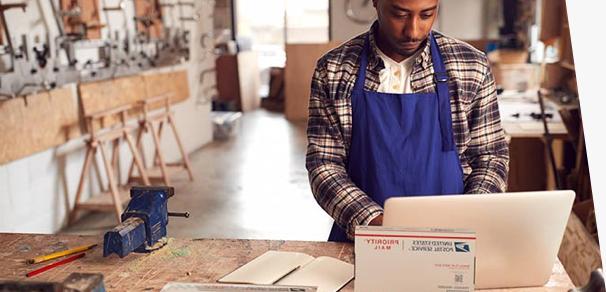 Small business owner preparing to ship 优先邮件 packages.